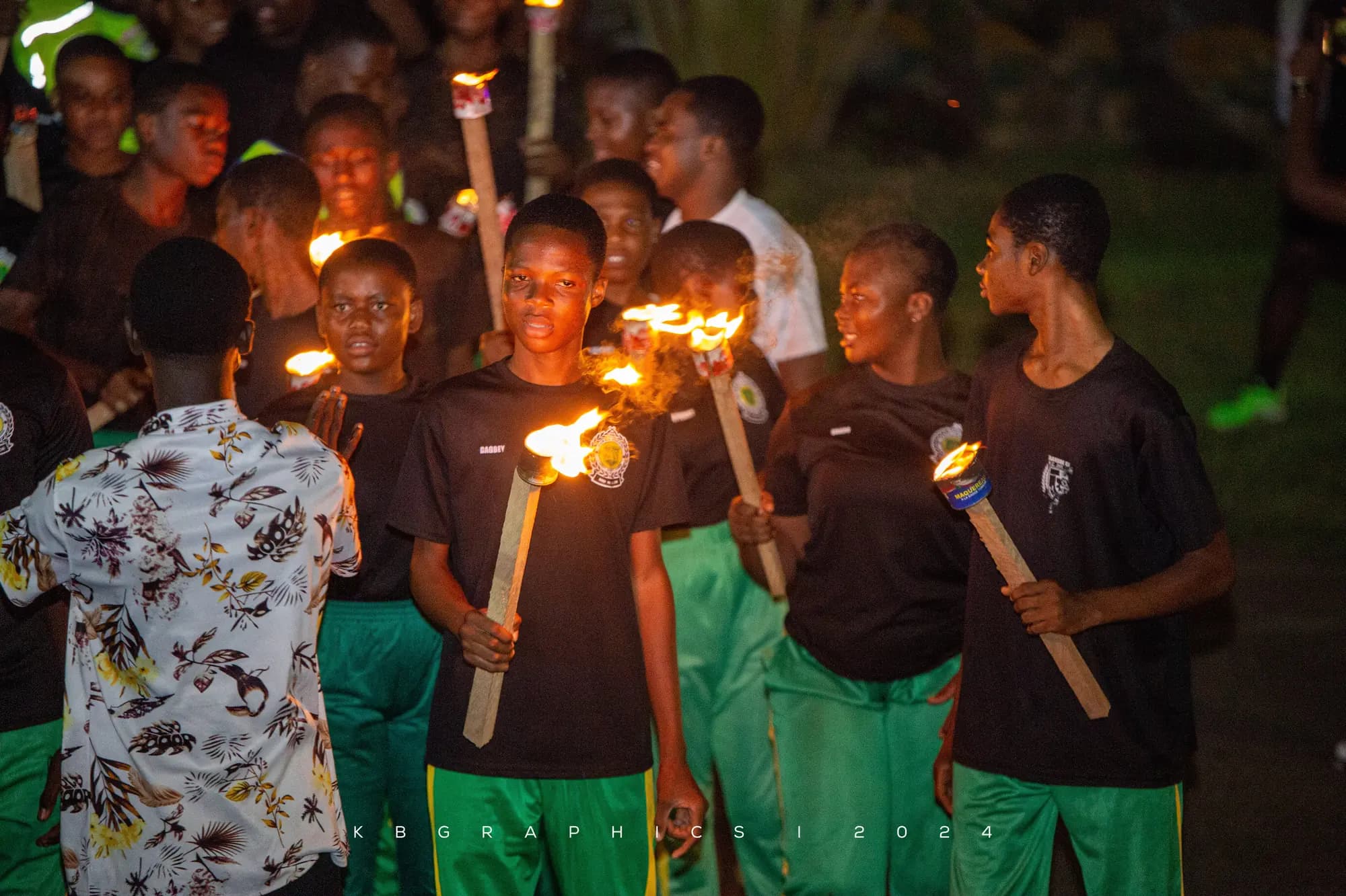 Students carrying flaming torches at night